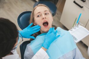 female dentist examining patient s mouth on dentis 2023 11 27 05 18 26 utc